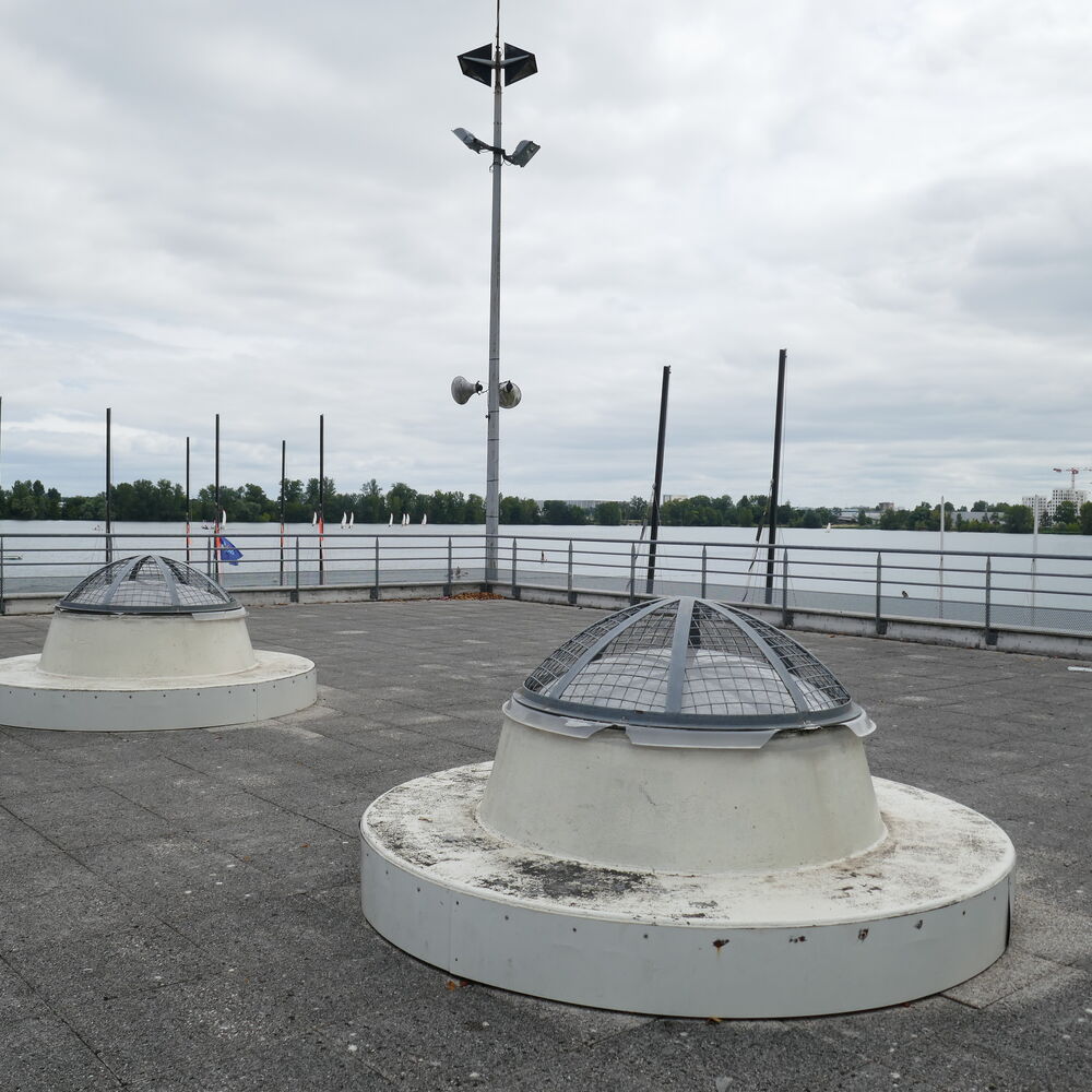 Le toit terrasse et ses puits de jour, vue vers le plan d'eau.