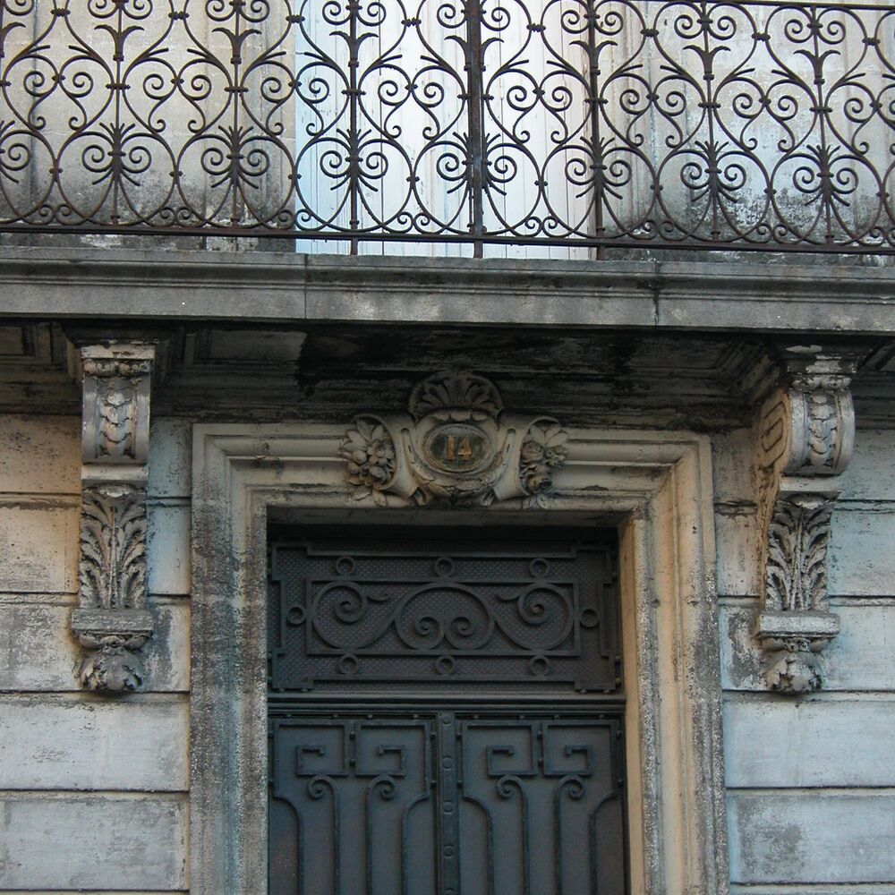 Détail d'une baie surmontée d'un balcon filant