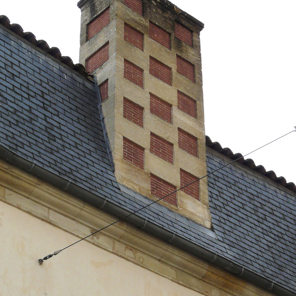 Souche de cheminée mêlant brique et pierre