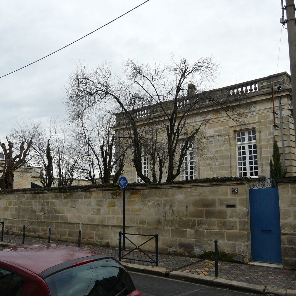 Mur de clôture sur la rue et aperçu de l'hôtel particulier