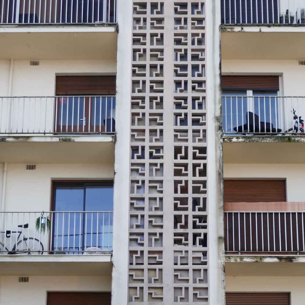 Détail de la façade principale avec la colonne de béton ajouré masquant les séchoirs des logements.
