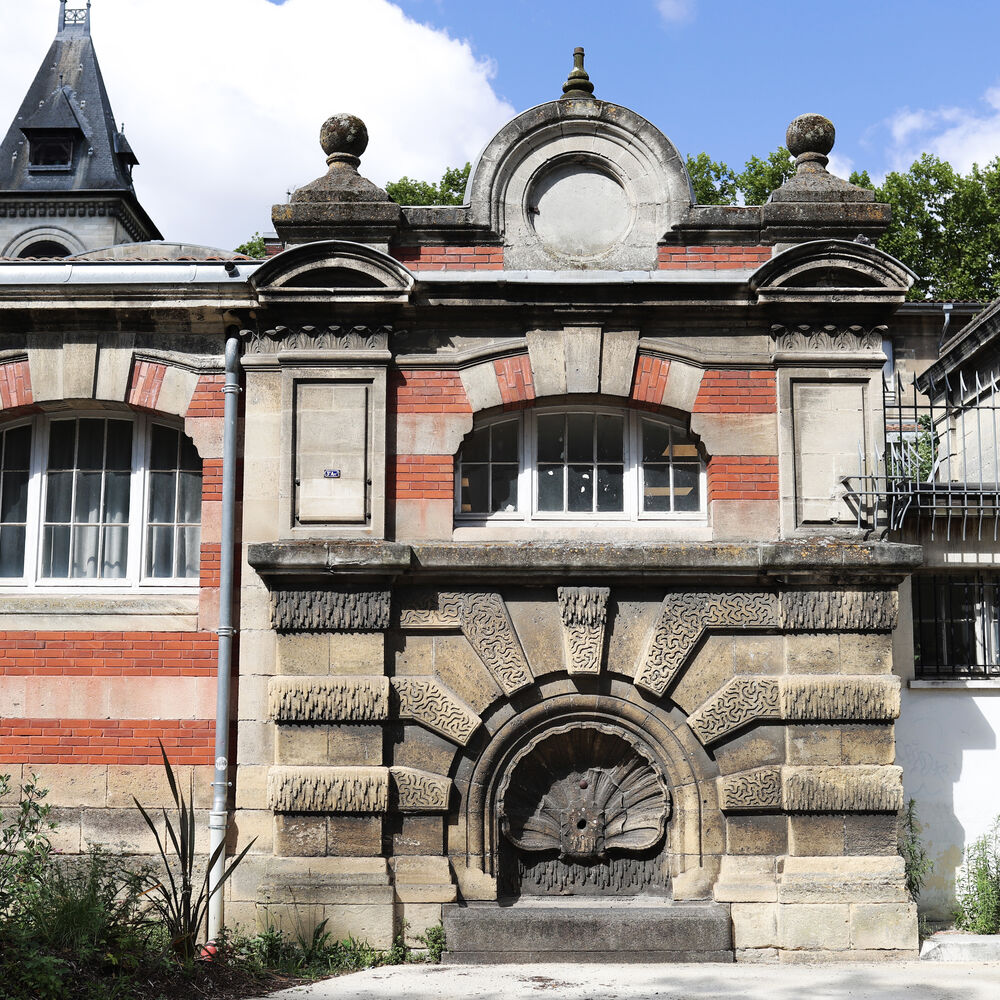 L'une des deux fontaines installées sur la façade de la rue Belleville.