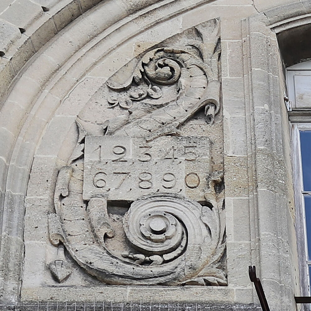 Bas-relief orné d'une table de chiffres dans l'un des frontons côté rue O'Reilly.