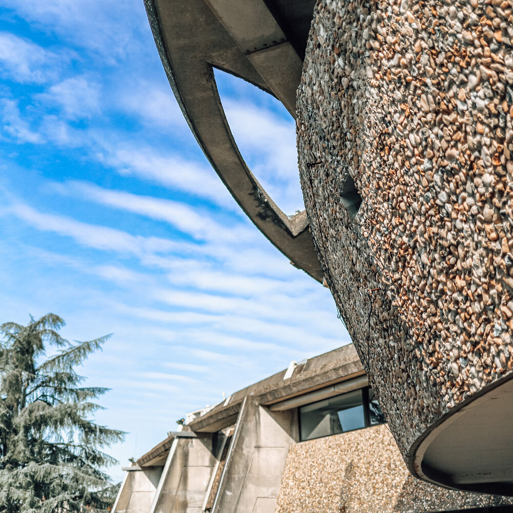Alternance des formes courbes et anguleuses entre le bâtiment et les places de parking.