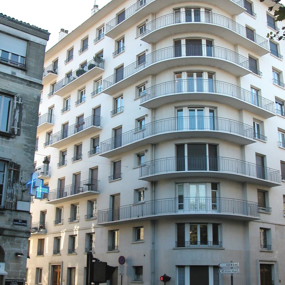 Vue d'ensemble de la résidence avec les balcons filants sur l'angle adouci.