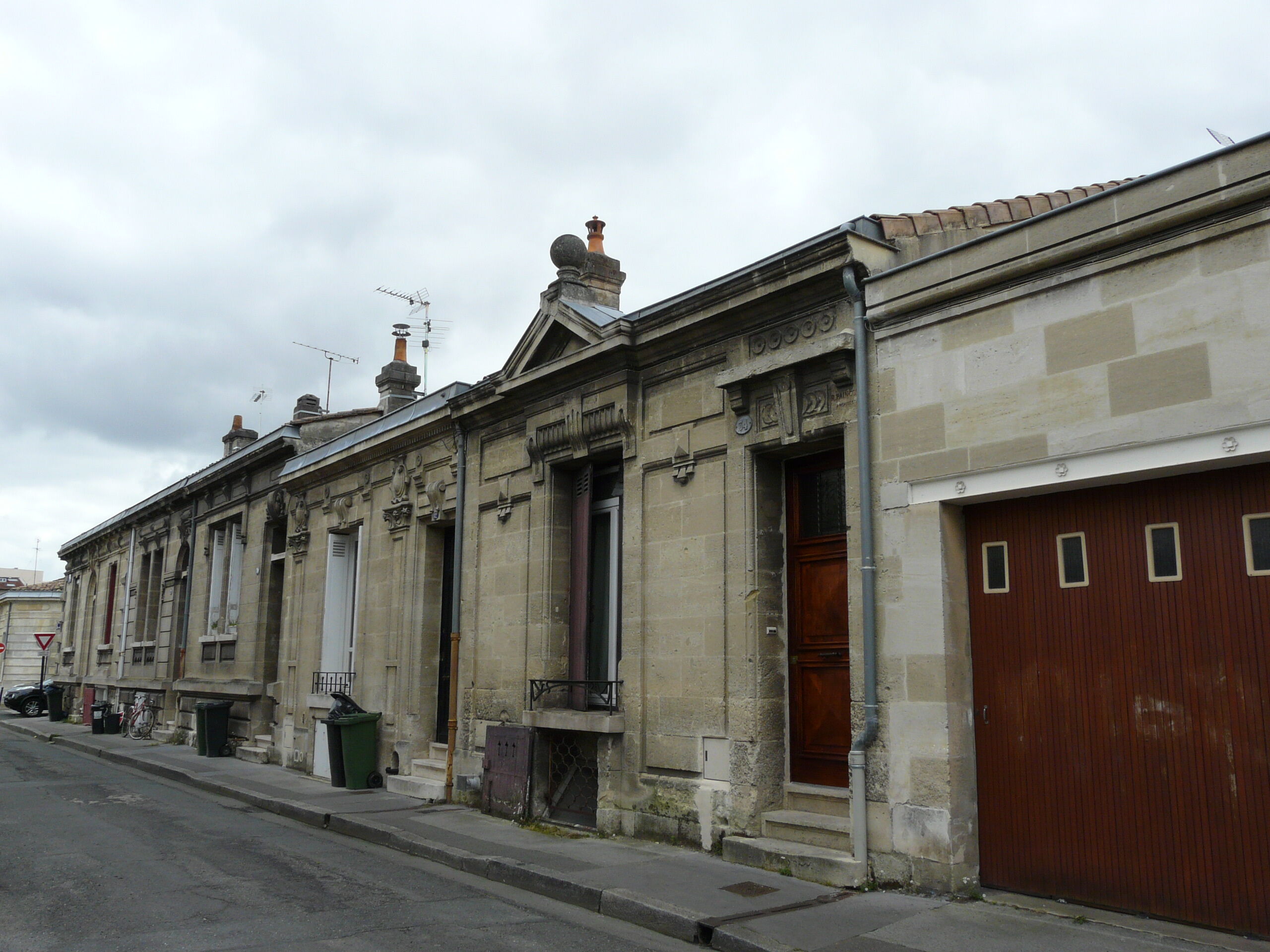 Vue du fronton couronné{e d'un globe, rue de Lescure. 