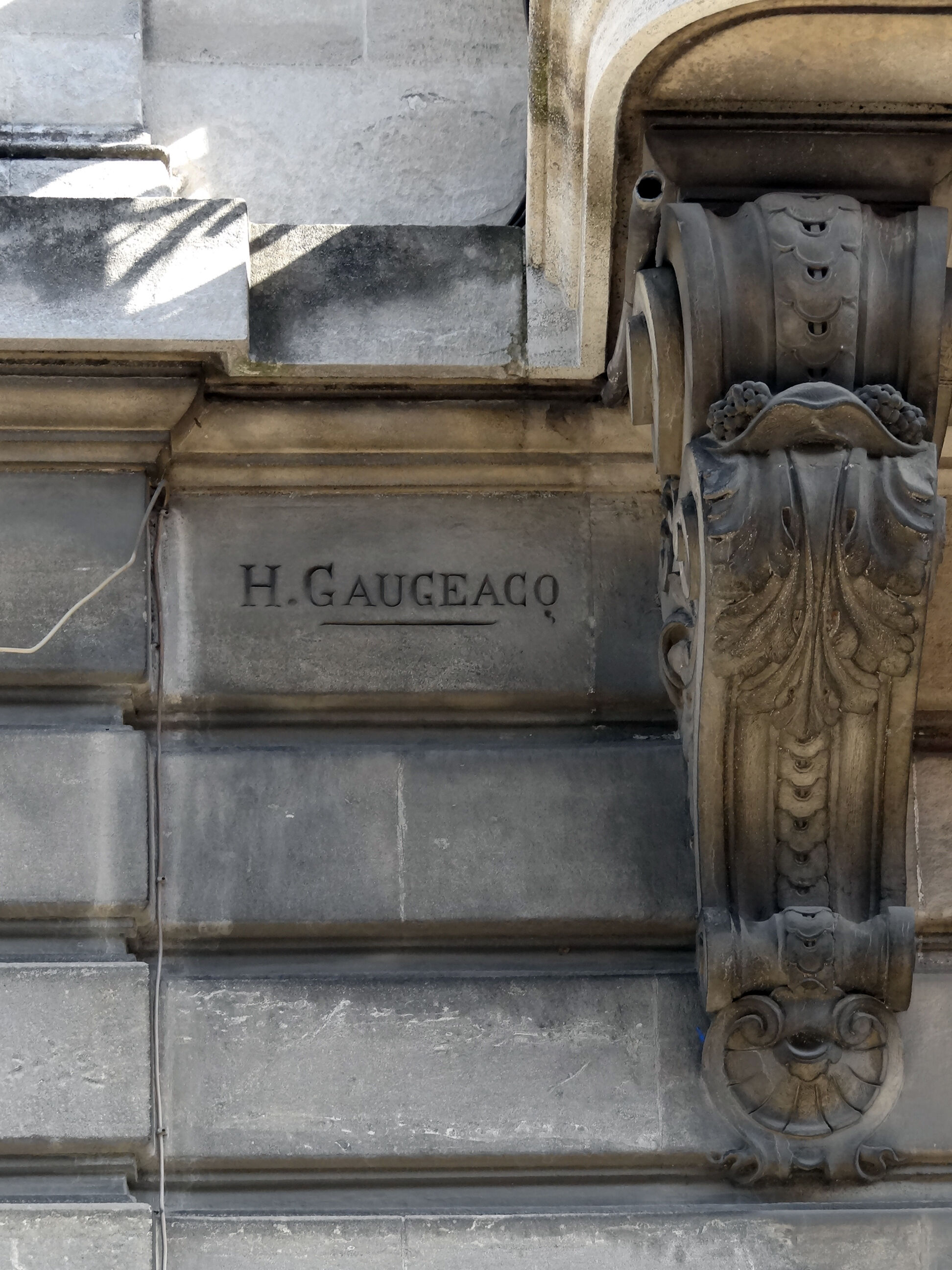 Signature de l'entrepreneur gravée dans une façade.