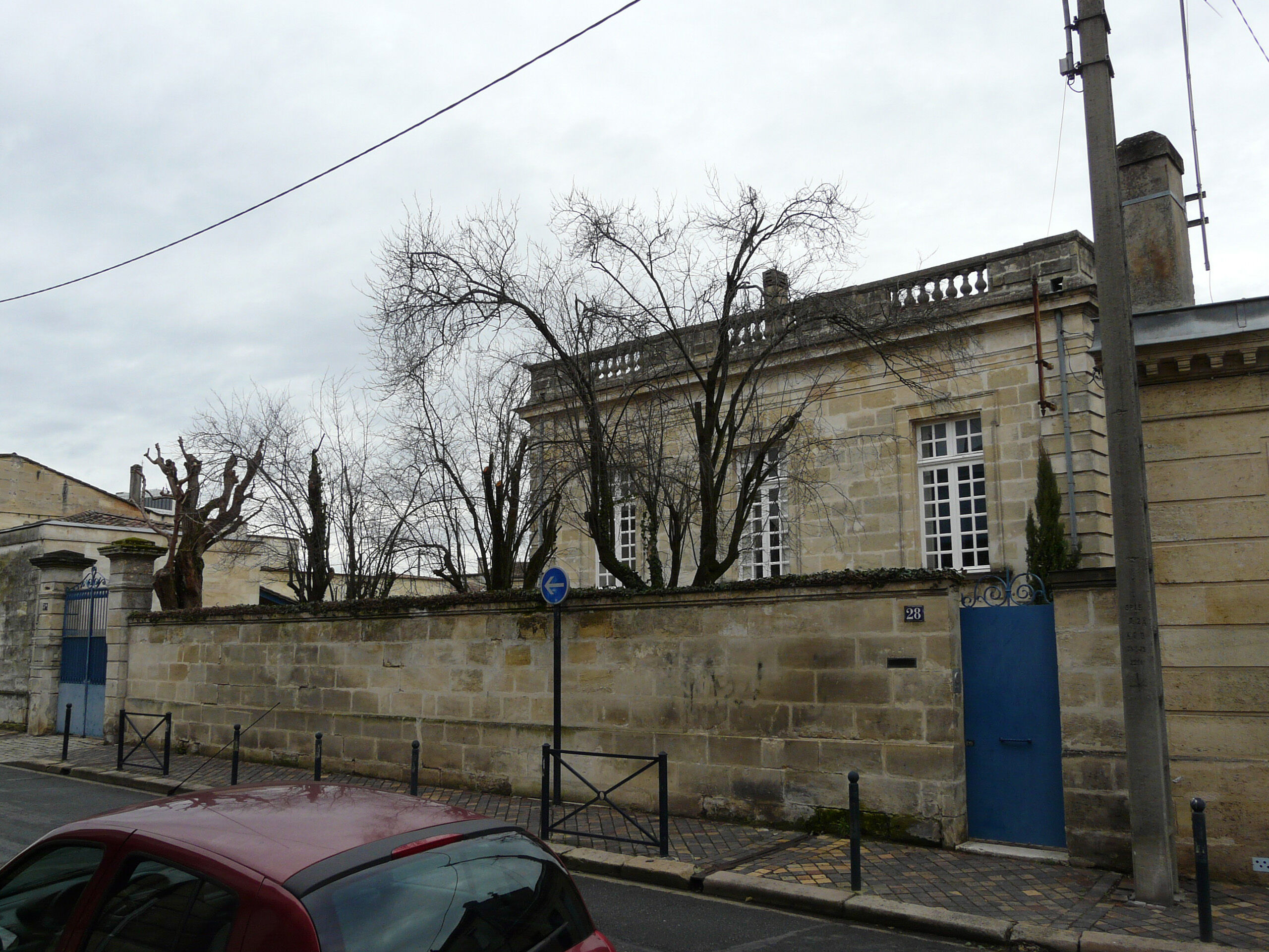 Mur de clôture sur la rue et aperçu de l'hôtel particulier