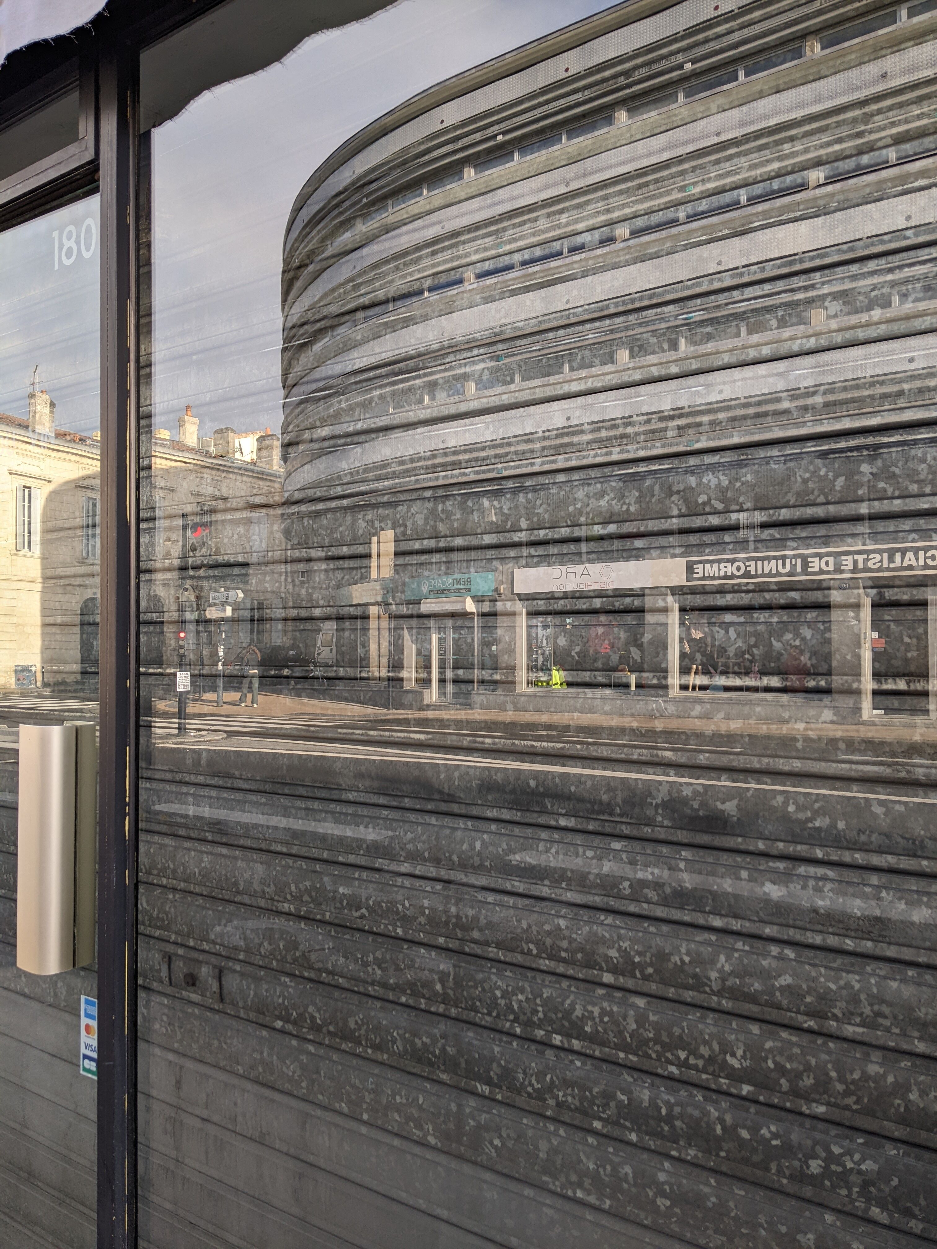 Reflet du bâtiment dans les vitrines en vis-à-vis sur le cours de la Marne.