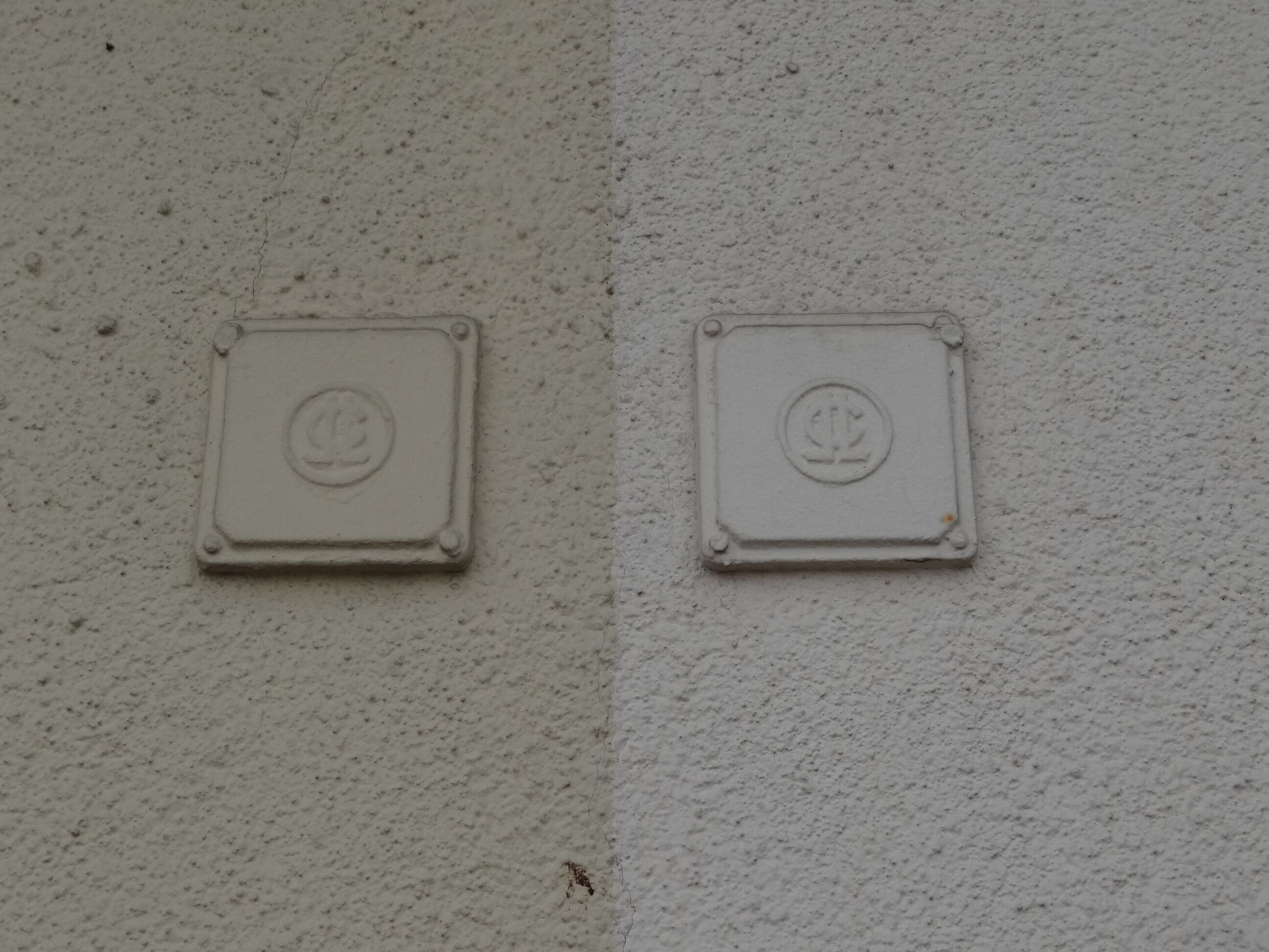 Le lettres entrelacées du COL dans des carreaux fixés sur les murs de chaque maison, en 2017.