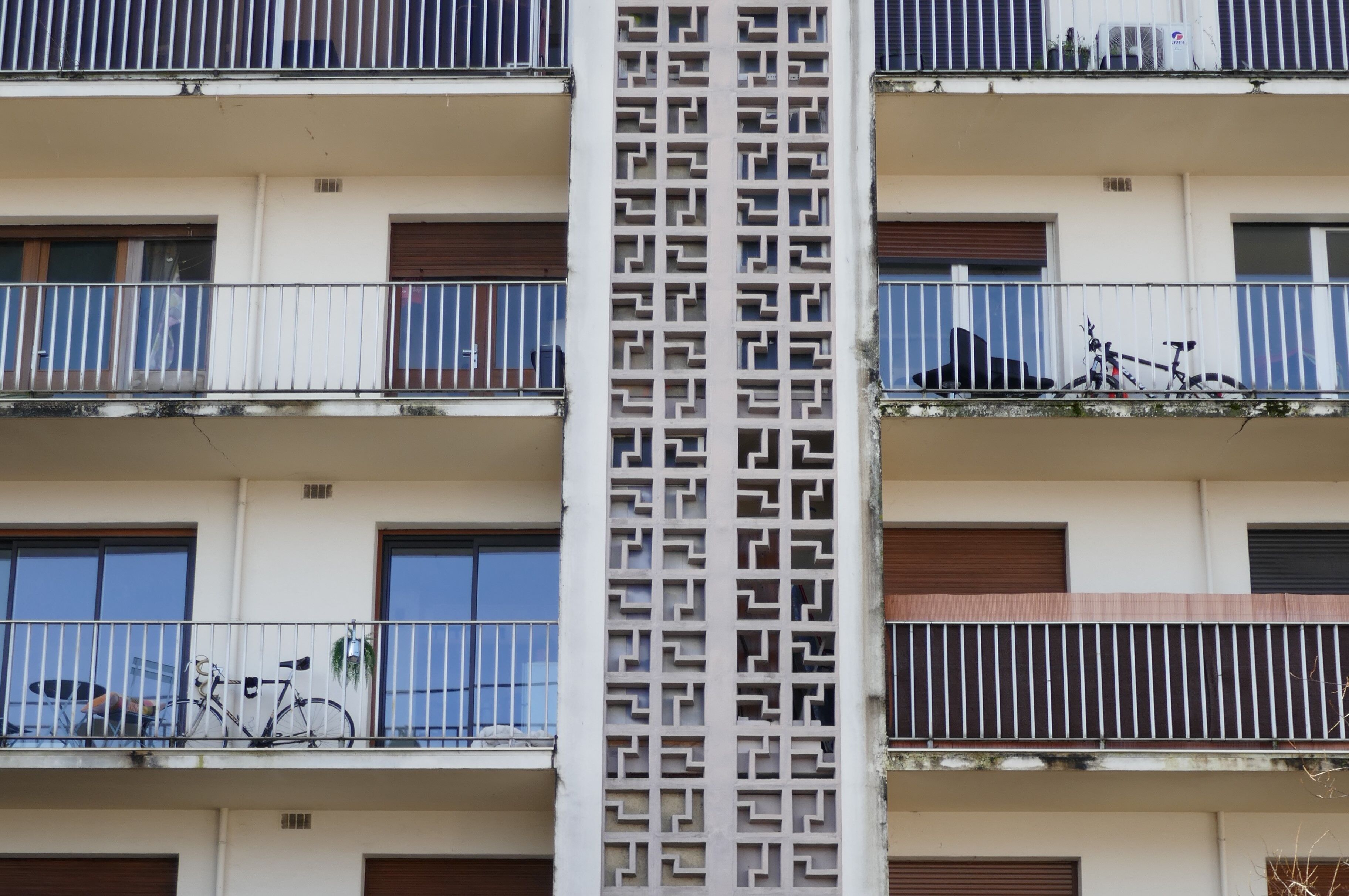 Détail de la façade principale avec la colonne de béton ajouré masquant les séchoirs des logements.