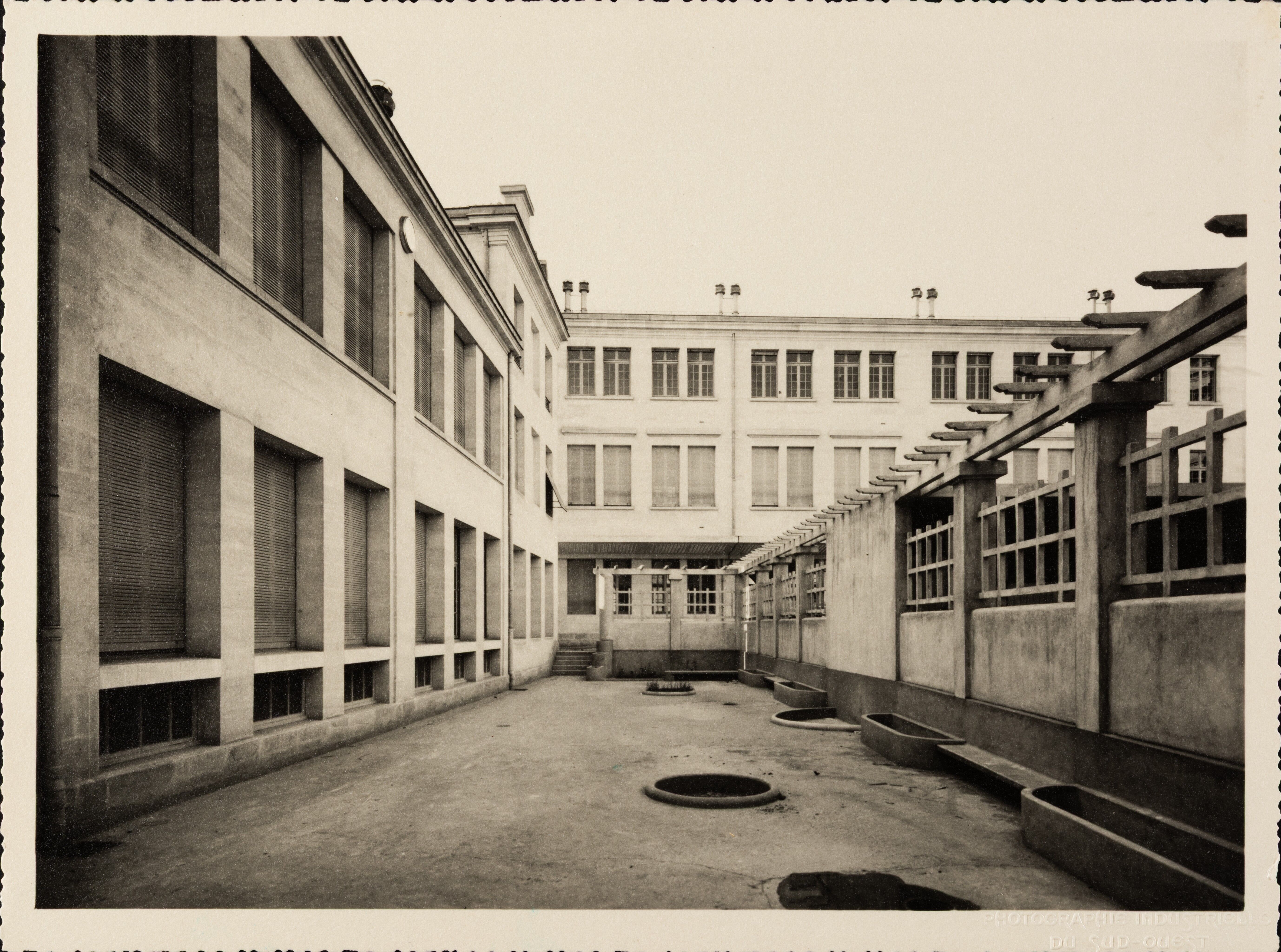 Façade et cour de l'école maternelle, vue prise vers l'école de fille, vers 1935.