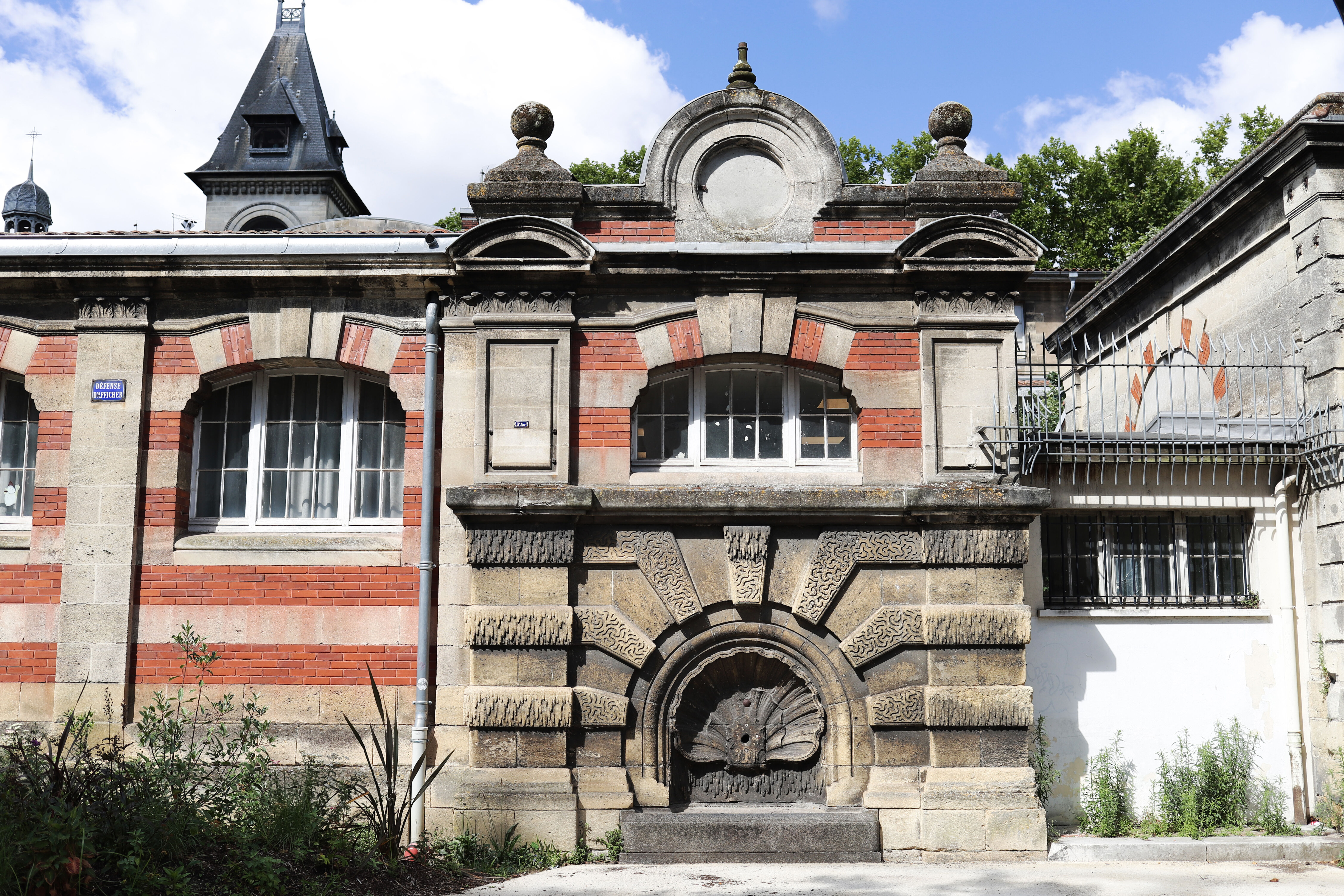 L'une des deux fontaines installées sur la façade de la rue Belleville.