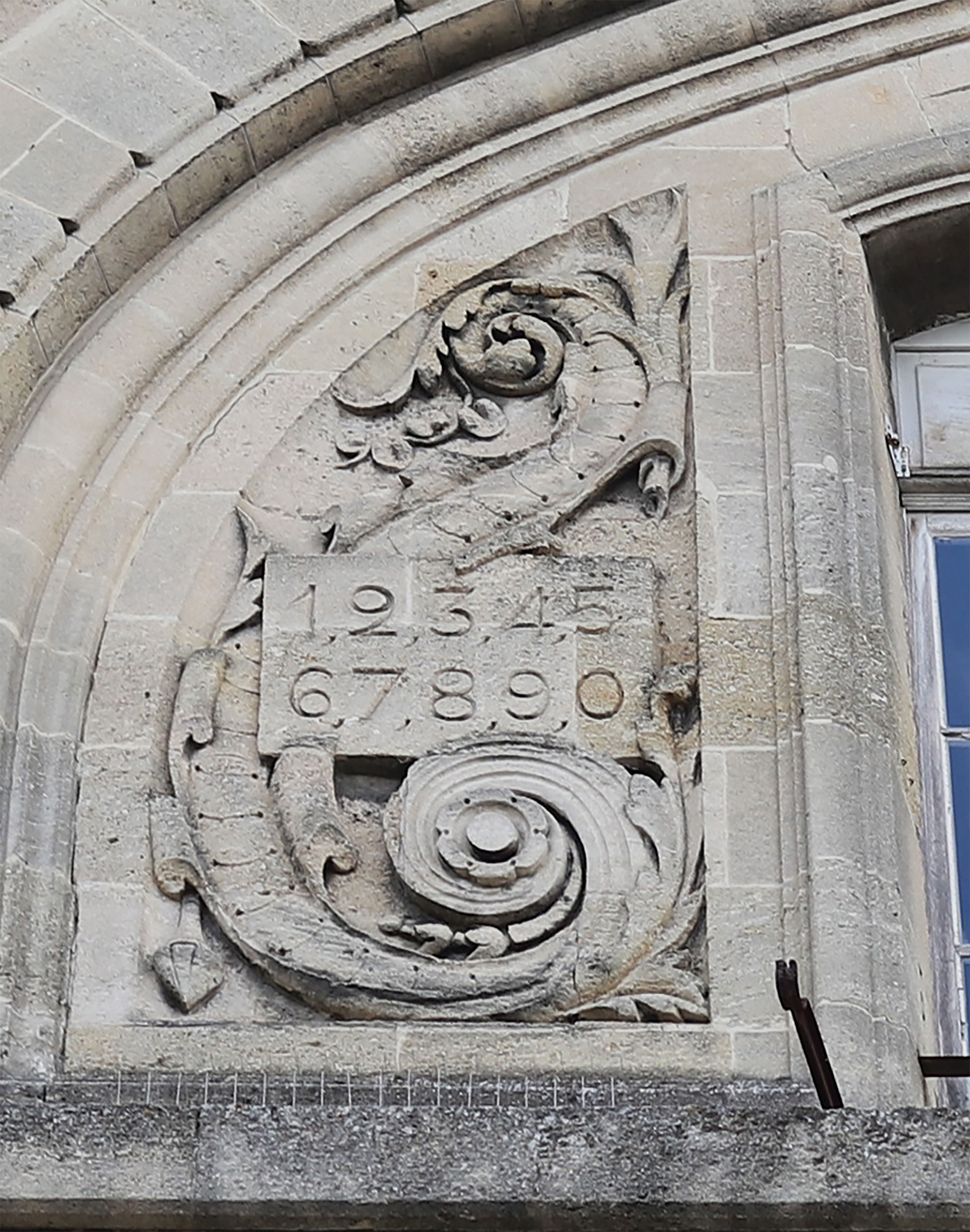 Bas-relief orné d'une table de chiffres dans l'un des frontons côté rue O'Reilly.