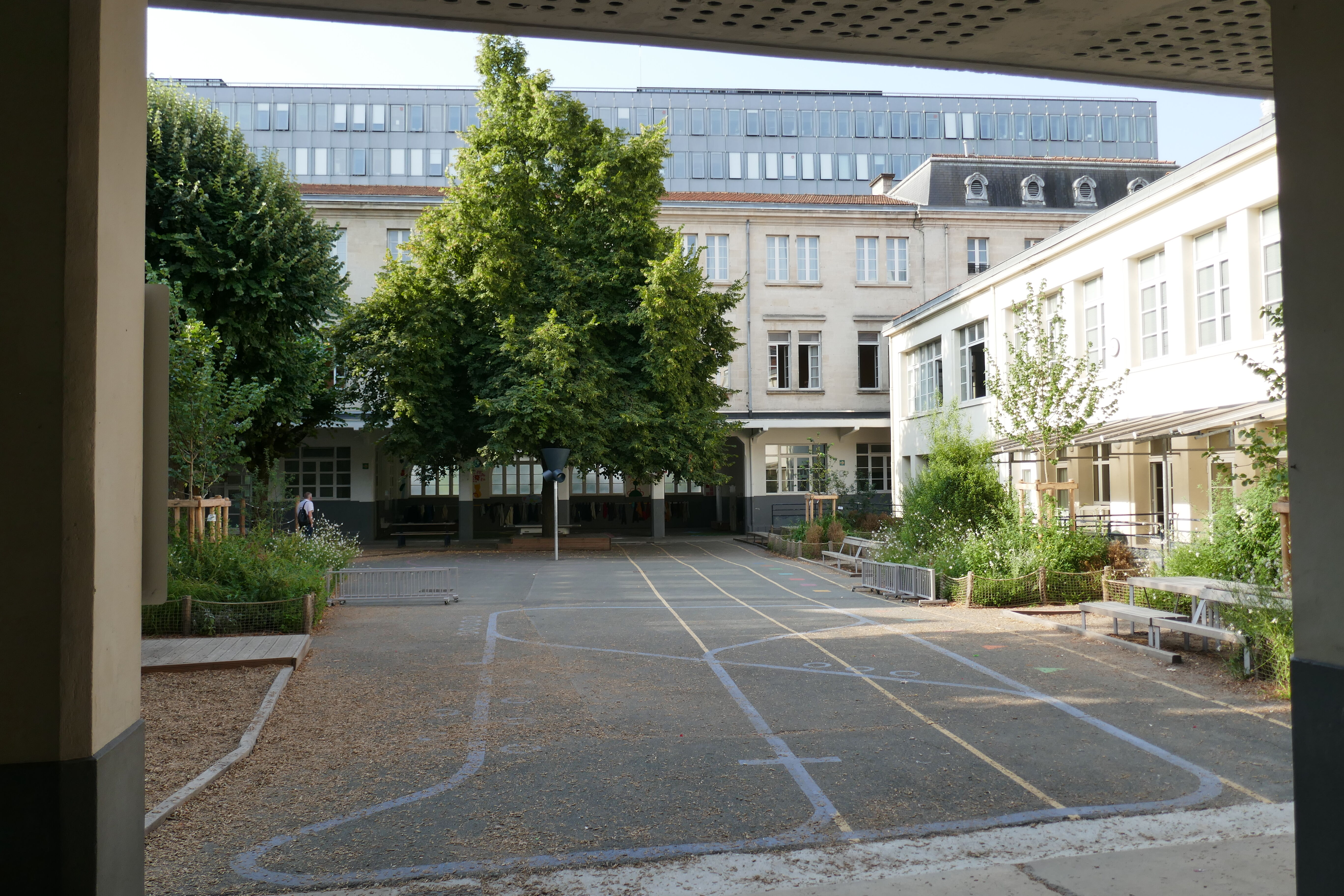 La cour du groupe scolaire avec, au fond, la cité municipale.