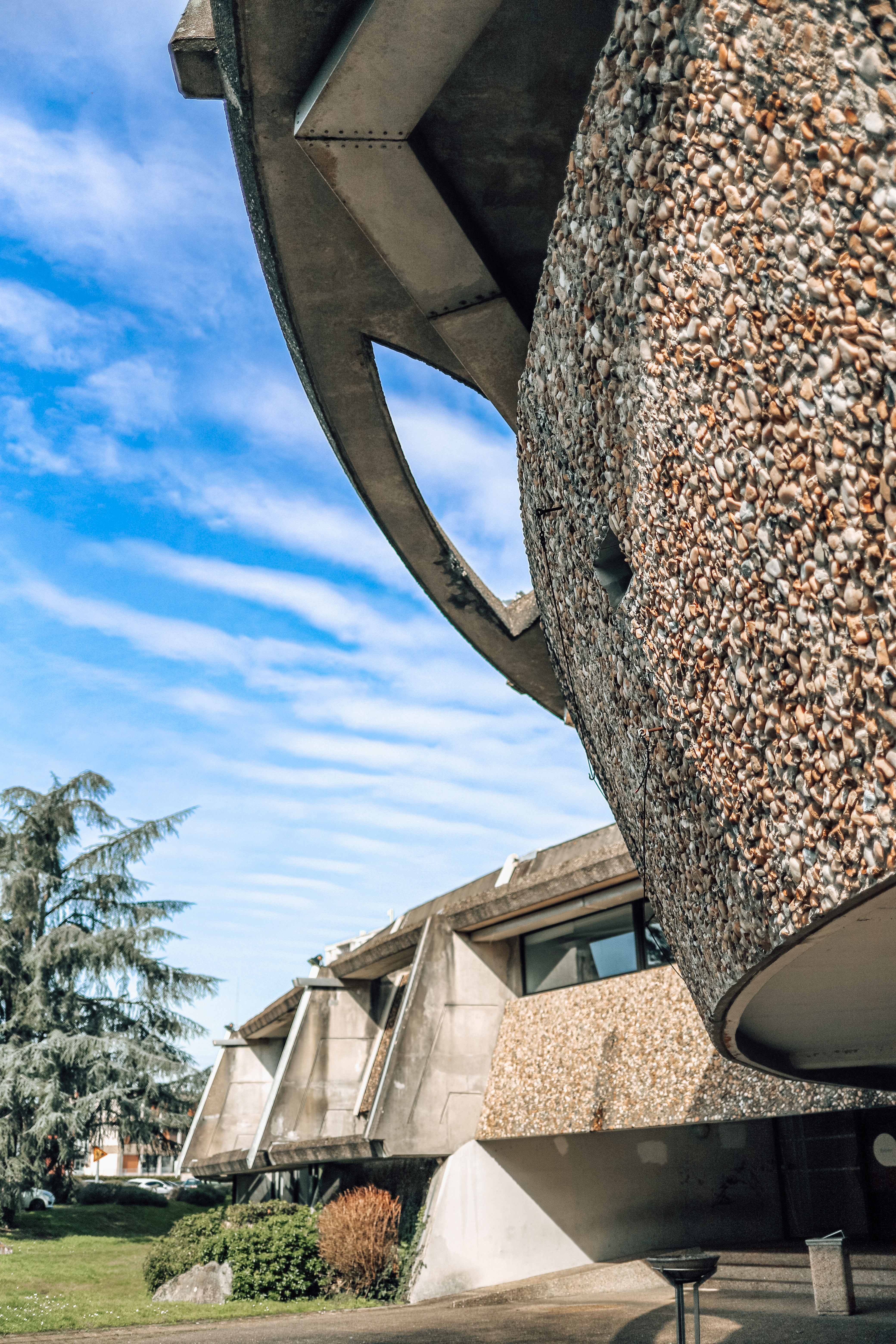 Alternance des formes courbes et anguleuses entre le bâtiment et les places de parking.